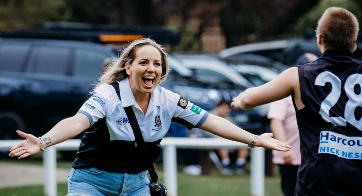 A disability Support Worker celebrating with a player Participation