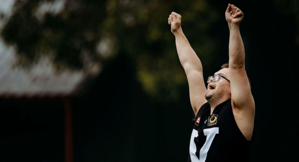 A young man with disability celebrating during and AFL match